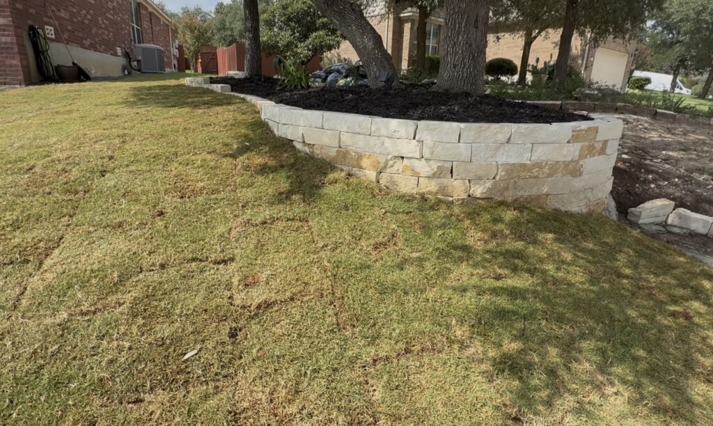 Limestone block raised bed around trees, with new sod in front